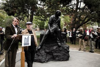 Dennis Lee standing with philanthropist Scott Griffin unveiling a bronze-statue of poet Al Purdy in Queen's Park