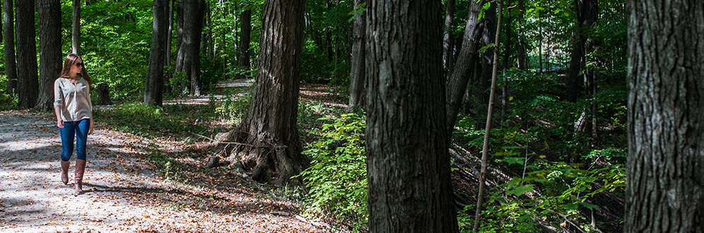 woman walking along a gravel trail in the woods