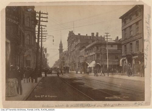 Busy street with streetcar tracks on it.