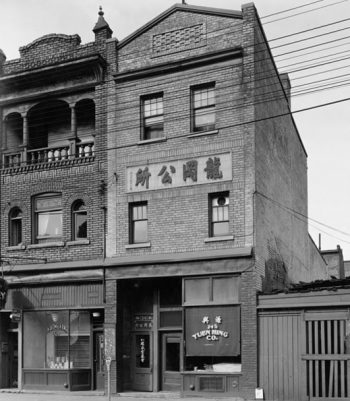 Three-storey brick building with signs in Chinese.