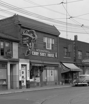 Two-storey brick building with neon sign saying International Chop Suey House.