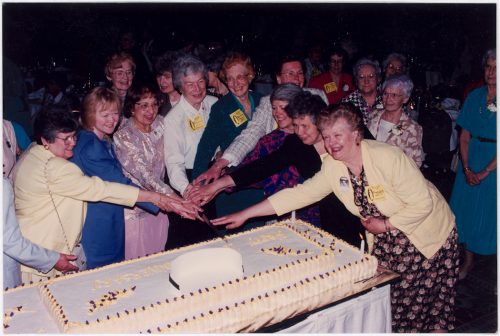 Alumnae Association past-presidents cutting 100th anniversary cake