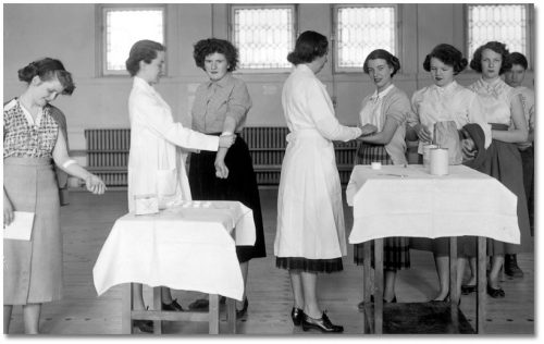 Teenaged girls extend their arms so nurses can stick bandaid-sized patches on them.