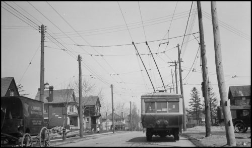 A small square bus with lines leading up to electrical wires above