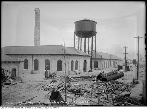 Long, low brick building and water tower.