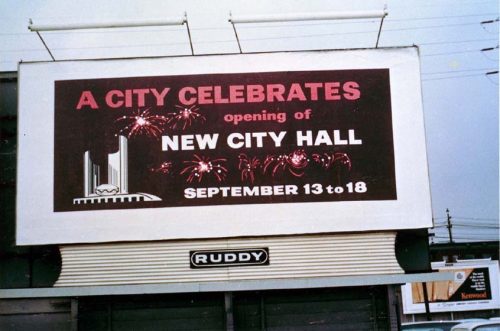 Billboard advertising City Hall opening celebrations, showing City Hall and fireworks