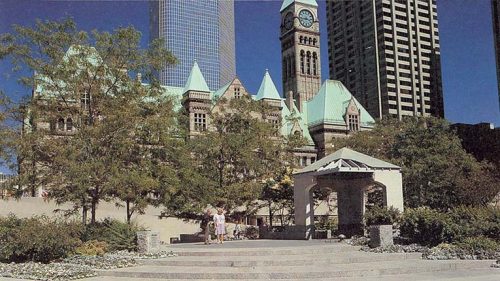 Peace garden with trees and broken structure, Old City Hall in background on a sunny day