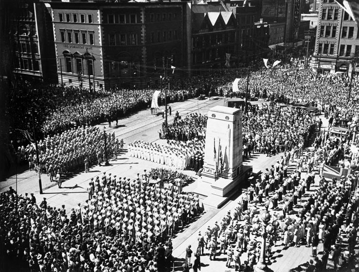 Crowd and armed forces personnel in formation seen from above.