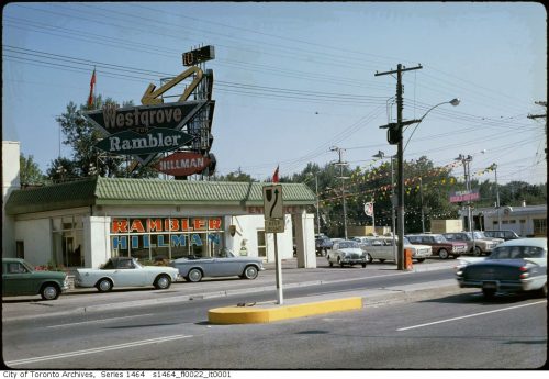 Car dealership building and parking lot with large dramatic sign.