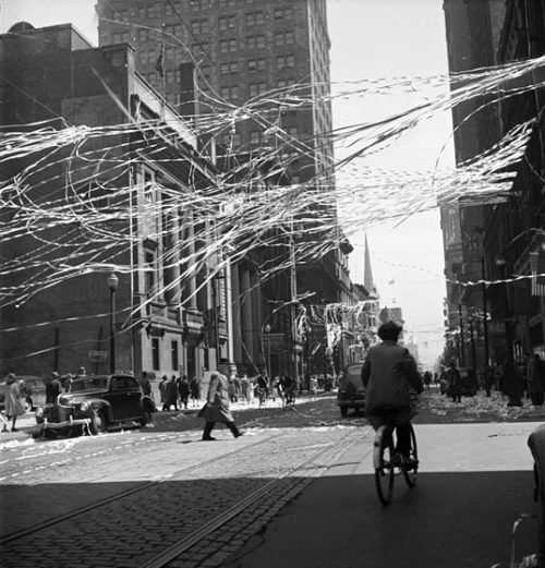 Long streamers flutter in the air above a city street.