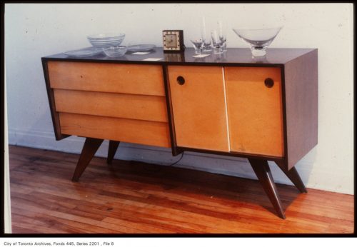 Low buffet with dark wood on outside and blonde wood doors.