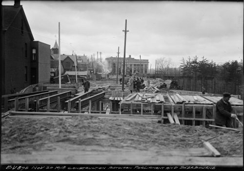 Metal and wood bridge being built between two sections of dirt road.