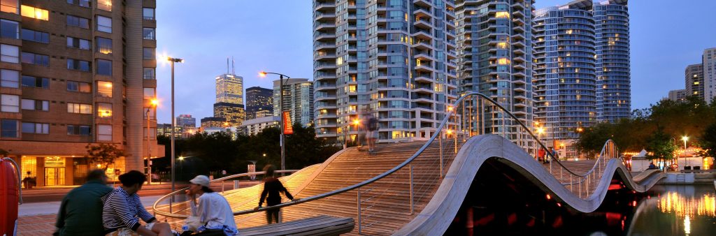 Night time photo of Simcoe Wave deck with people sitting on benches
