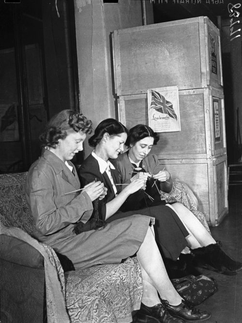 Dorothy McCabe, Queenie Edward, and Edith Allen knitting in a Red Cross workroom.