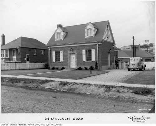 Small Cape Cod style house with Volkswagen bug in driveway.