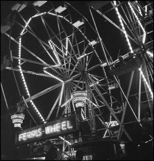 Ferris wheel with wheel and spokes outlined in lights.