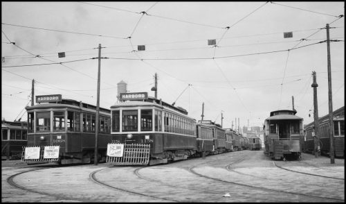 Rectangular streetcars with the word Harbord on the front lined up.