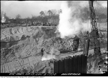 Steam-powered construction equipment on cleared bare ground.