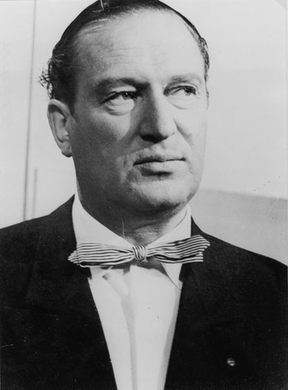 A middle-aged white man wearing a dark suit and bow tie