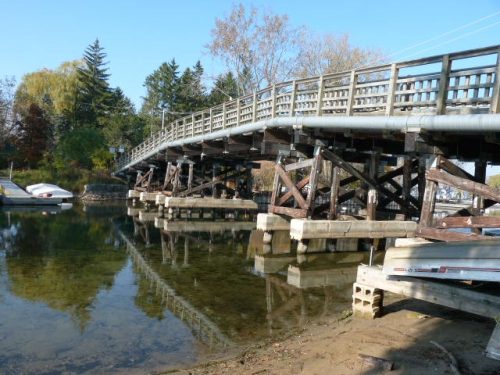 Modern photograph of the Algonquin Island Bridge showing it sitting on top of concrete and wooden stilts.