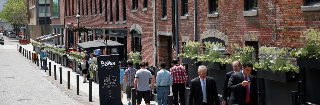 historic brick buildings and cobblestone street with people walking