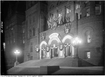 Front of Old City Hall with sign saying "God Bless the Prince of Wales" and many Union Jack flags.