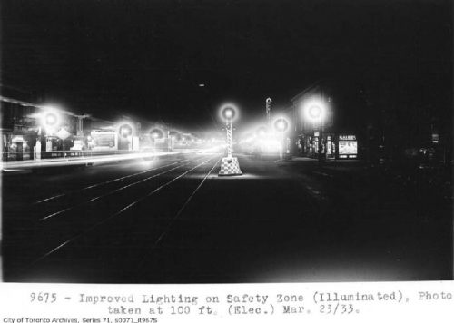 Lights on both sides of a road and on the boulevard in the middle.