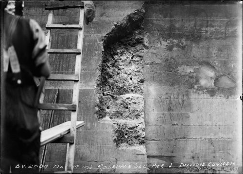 Large concrete pier with a hole where chunks of concrete fell off it.