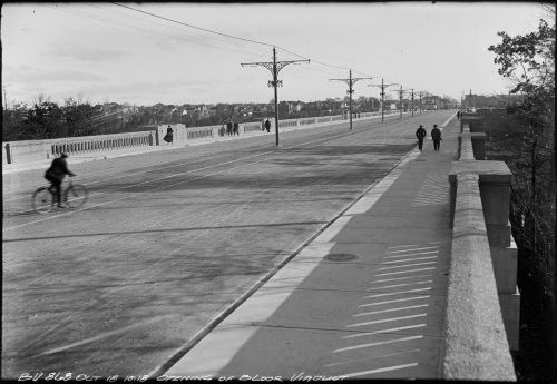 Roadbed of viaduct with pedestrians and a cyclist.