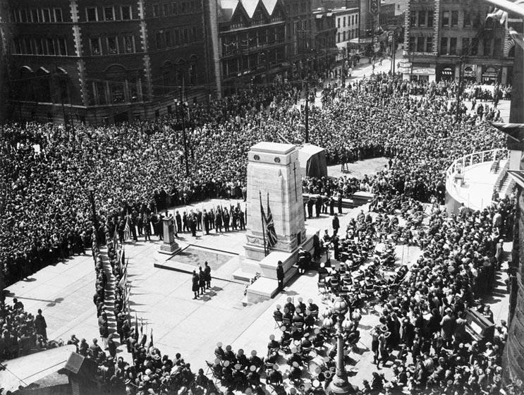 Crowd at Old City Hall stone cenotaph seen from above.