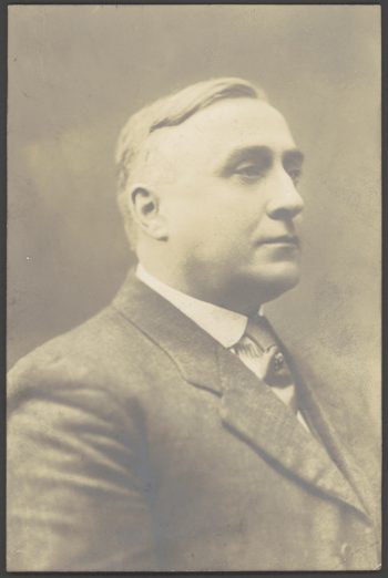 White man with blonde hair in suit.