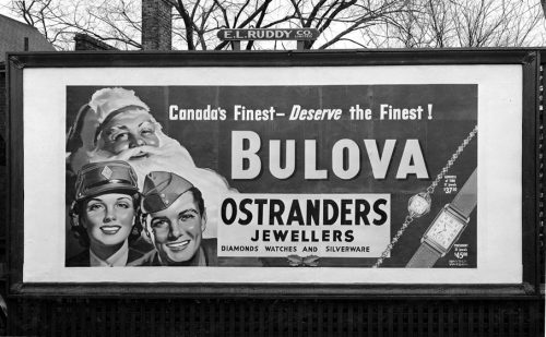 Billboard showing man and woman in armed forces uniforms with Santa Claus.