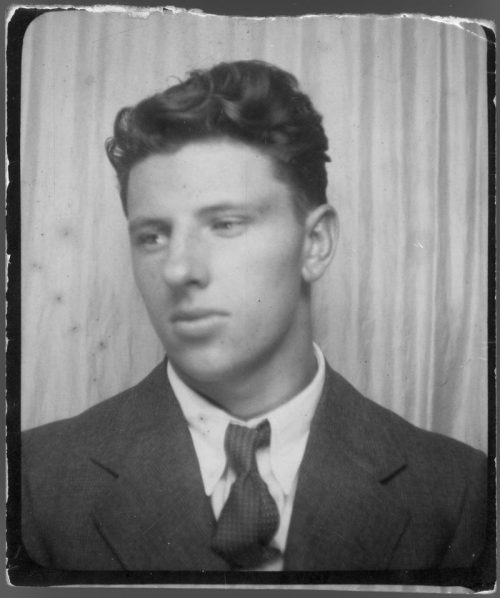 Head and shoulders of young man with dark hair in a suit.