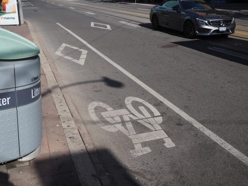 Painted bicycle lane on Bay St north of Dundas St W, which contains a diamond and bicycle symbol.