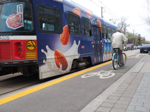 Cyclists waits 2 meters behind the streetcar doors before continuing forward