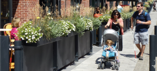 Image of pedestrians walking along Market Street alongside outdoor cafe seating. 