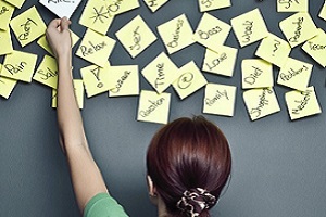 Lady Adding Post-It Note to Wall