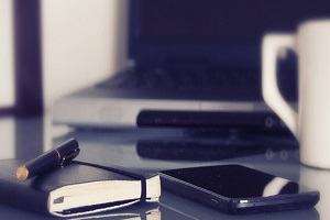 Desk with Notebook, Cell Phone and Coffee Mug on it