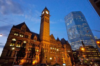 A view of Old City Hall at dusk from the Queen Street side and the facade illuminated with soft lighting.