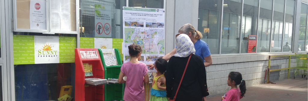 City Staff talking to a young family at a Don Mills Crossing pop-up engagement event.