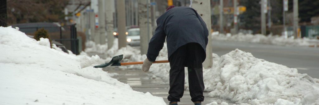 Image of man, clearing the snow on the sidewalk