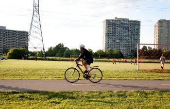 Cyclist on path by soccer field