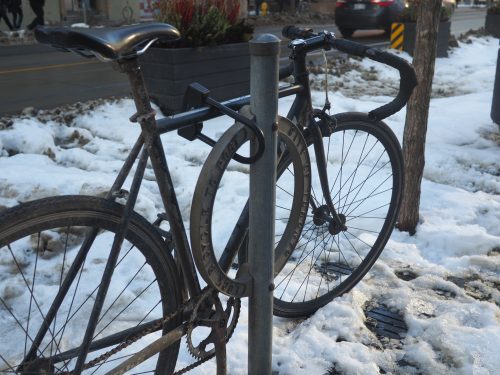 A bicycle locked to an original 1984 designed post and ring