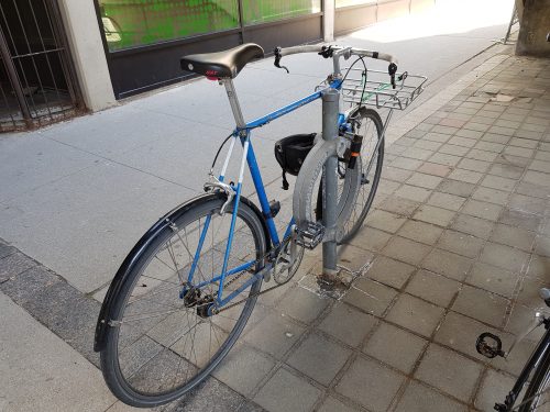A bicycle is locked to a Toronto Post and Ring. The rack provides a convenient place to lock the frame and a wheel providing additional safety