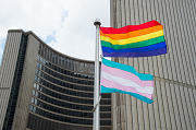 A Pride flag with the Toronto City Hall towers in the background