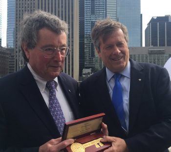 Paul Beestong and Mayor John Tory hold a key to the city on the Toronto City Hall Green Roof.