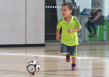 boy playing indoors with a soccer ball at a City of Toronto recreation centre