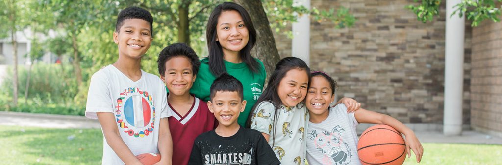 Recreation staff posing with five with children and a basketball