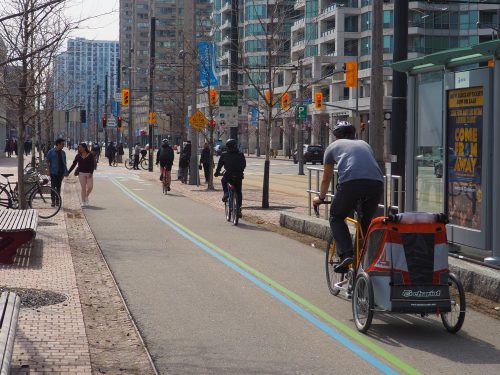 People cycle and walk on the shared Martin Goodman multi-use trail through downtown.