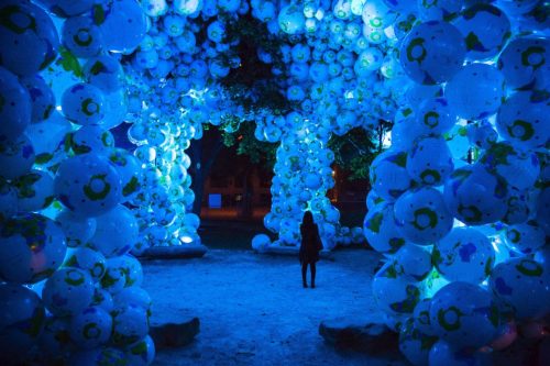 Person walking through exhibiton filled with blow up balls. Exhibition from 2014 Nuit Blanche - 'Walk Among Worlds'